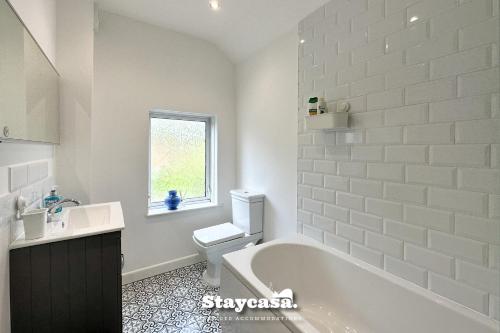 a bathroom with a tub and a toilet and a sink at Stunning 3bdr 2ba House With Free Street Parkin in Birmingham