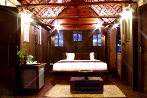 Un dormitorio con una cama en una habitación con luces. en Terrapuri Heritage Village, Penarik, en Kampung Penarik