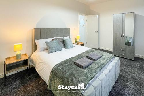 a bedroom with a large bed with two pillows on it at Princess Hideout 5min to City with Street… - 19976 in Manchester