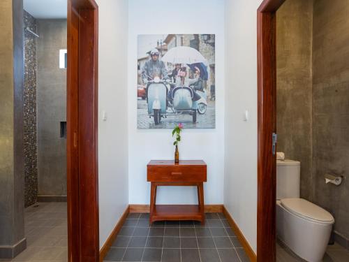 a bathroom with a toilet and a picture on the wall at Grand Yard La Residence in Siem Reap