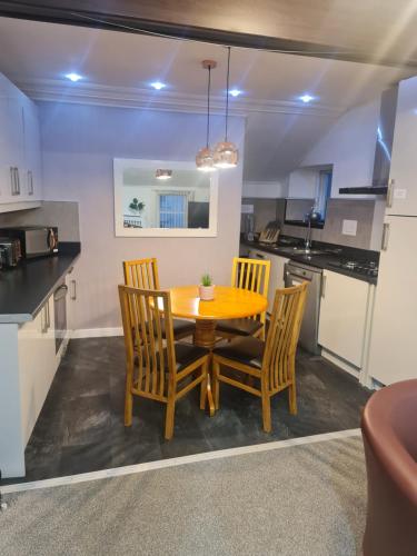 a kitchen and dining room with a wooden table and chairs at Ulverston Town Centre Flat (2 Bedrooms) in Ulverston