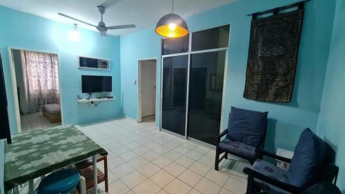 - un salon avec des murs bleus, une table et des chaises dans l'établissement Edaman Guest House, à Kota Kinabalu