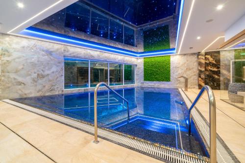 a large lap pool in a house with blue water at Piastun SPA&Wellness Krynica-Zdrój in Krynica Zdrój