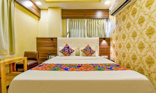 a bedroom with a large bed in a room at FabHotel Raj Palace I in Vadodara