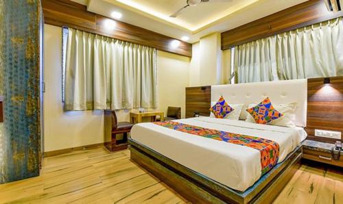 een slaapkamer met een groot bed in een kamer bij FabHotel Raj Palace I in Vadodara