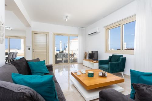 a living room with a couch and a table at Villa Diana Seaside in Pomos