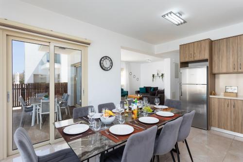 a dining room and kitchen with a table and chairs at Villa Diana Seaside in Pomos