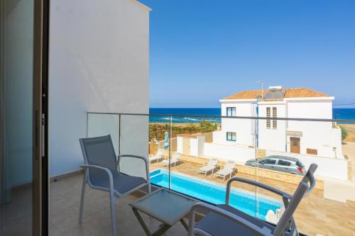 a balcony with a view of a pool and the ocean at Villa Diana Seaside in Pomos