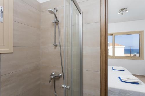 a shower with a glass door in a bathroom at Villa Diana Seaside in Pomos