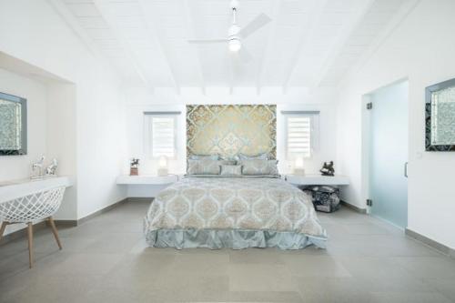 1 dormitorio con 1 cama grande en una habitación blanca en La Perla Bianca - 1 BR Beachfront Luxury Villa offering utmost privacy en Les Terres Basses