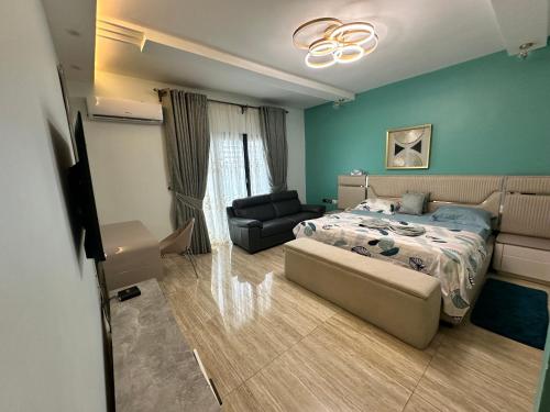 ein Schlafzimmer mit einem Bett und einem Sofa in der Unterkunft Villa Only in Douala