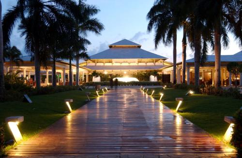 a walkway leading to a building with palm trees at Catalonia Punta Cana - All Inclusive in Punta Cana
