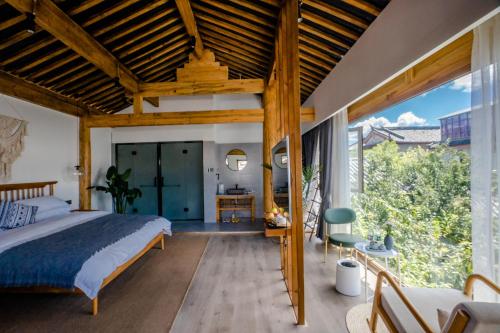 a bedroom with a bed and a large window at Lijiang One House Designer Guesthouse in Lijiang