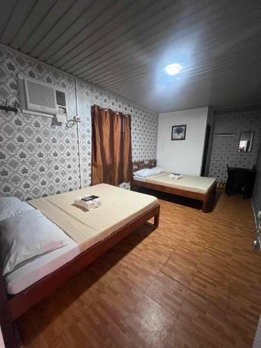 RedDoorz @ Boondocks Cabins Resort في Dalumpinas Oeste: غرفة نوم بسريرين وطاولة فيها