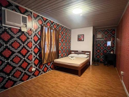 RedDoorz @ Boondocks Cabins Resort في Dalumpinas Oeste: غرفة بسرير وجدار به نمط