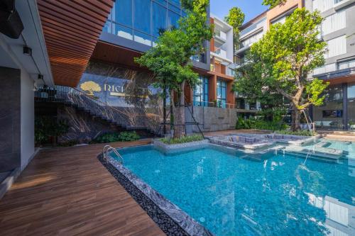 a swimming pool in front of a building at Richmann Resort Hotel Hatyai in Hat Yai