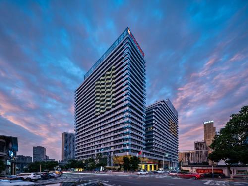 un edificio alto en una ciudad con un cielo nublado en Hilton Garden Inn Nanchang, en Nanchang