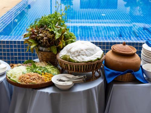 a table with three baskets of food on it at Grand Yard La Residence in Siem Reap