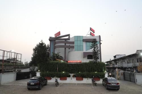 a parking lot with cars parked in front of a building at Hotel Gokul in Gandhidham