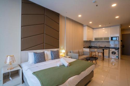 a bedroom with a large bed and a kitchen at Societe Suites By iHost Global in Kuala Lumpur