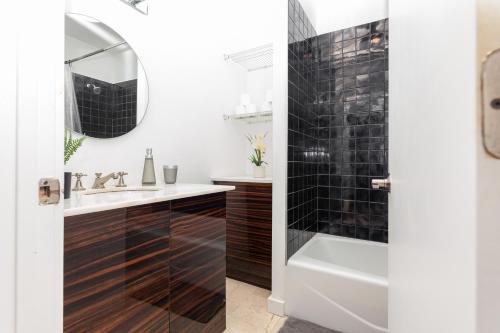 a bathroom with a tub and a sink and a mirror at Home Miami Downtown - 5 minutes from Wynwood & Port - near Beach in Miami