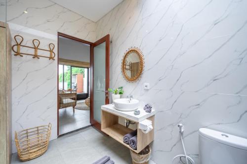 a bathroom with a sink and a mirror at Kulta Villa Bali in Munggu