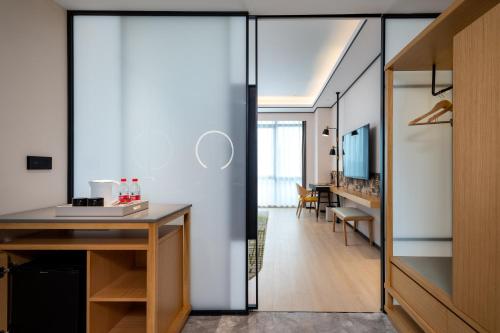 a room with a desk and a hallway at Hilton Garden Inn Nanchang in Nanchang