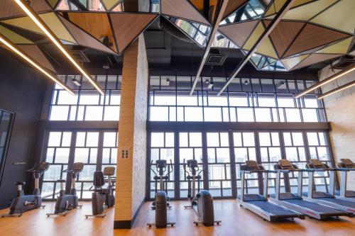 a gym with a row of treadmills and ellipticals at Societe Suites By iHost Global in Kuala Lumpur