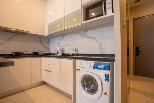 a kitchen with a washing machine in a kitchen at Societe Suites By iHost Global in Kuala Lumpur
