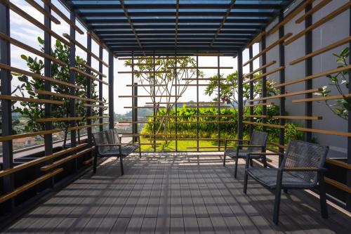 a balcony with chairs and a view of a garden at Societe Suites By iHost Global in Kuala Lumpur