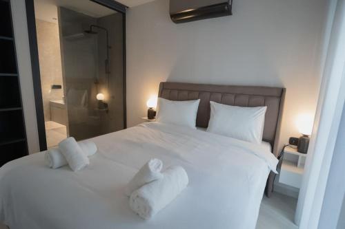 een slaapkamer met een wit bed en handdoeken bij ID Residences 203 in Volos