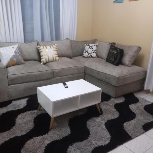 a living room with a couch with a white coffee table at Gateway Homes in Nairobi