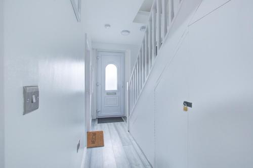 um corredor com paredes brancas e uma porta branca em CrossVille Homes - 7 bed house, 3 baths, 3 parking em Navestock