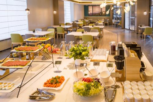 a buffet of food on a table in a cafeteria at Atour Hotel Weifang Jinma Road City Hall in Weifang