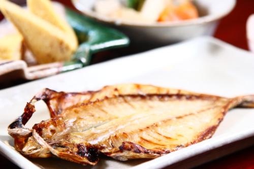 a fish on a white plate on a table at IZUNA INN & SPA - the veggie delights in Ito