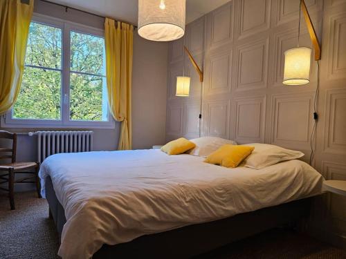 - une chambre avec un grand lit et 2 oreillers jaunes dans l'établissement Le Haut Puits Amboise Tours piscine dans grand parc, à Reugny