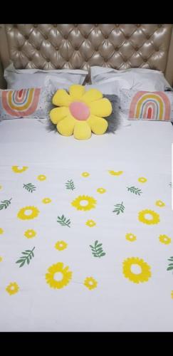 a bed with a yellow flower printed on it at Angelhome 