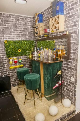 a bar with two green stools in front of a brick wall at Angelhome 