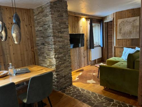 a living room with a stone wall and a table at Chalet Apart Hansler in Ehrwald