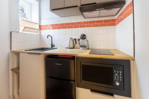 a small kitchen with a sink and a microwave at Cozy Apt in Central London in London