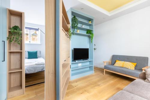 a living room with a couch and a tv at Cozy Apt in Central London in London