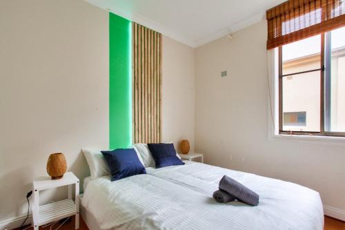 シドニーにある2 Bedroom Apartment Newtown Near to Shops 2の緑色のアクセントの壁の白いベッドが備わるベッドルーム1室