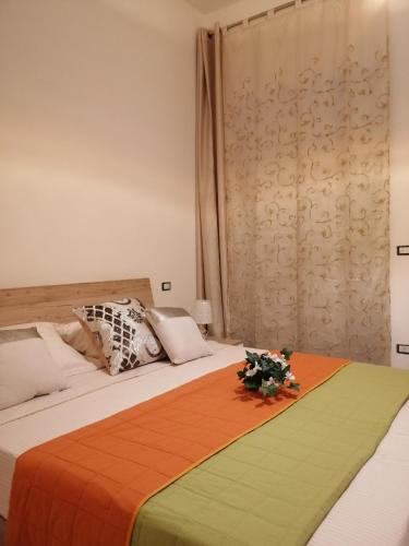 a bedroom with a bed with an orange and green blanket at Onde Salentine Deluxe in Casalabate