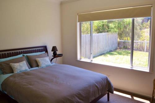 um quarto com uma cama e uma grande janela em BLAIRGOWRIE BEACH SHACK..bay beach location em Blairgowrie
