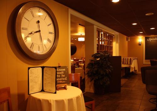 un orologio sul muro di un ristorante con tavolo di Macaluso's at the Lantern Lodge a Jim Thorpe