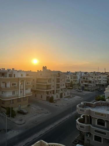 a sunset over a city with apartment buildings at Villamar Sea View rooms & apartments in Hurghada
