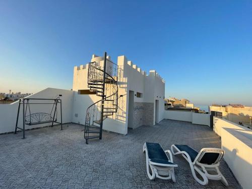a rooftop with two chairs and a staircase on a building at Villamar Sea View rooms & apartments in Hurghada