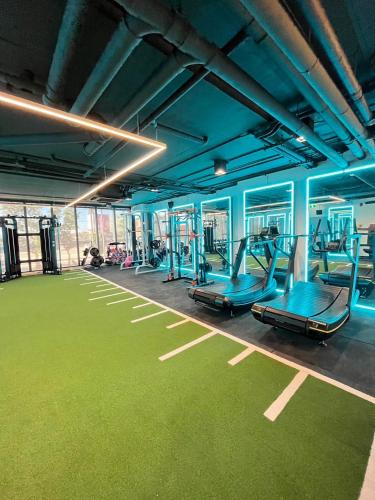 a gym with blue walls and green flooring at 9D City & 9D Express Hotel in Udon Thani