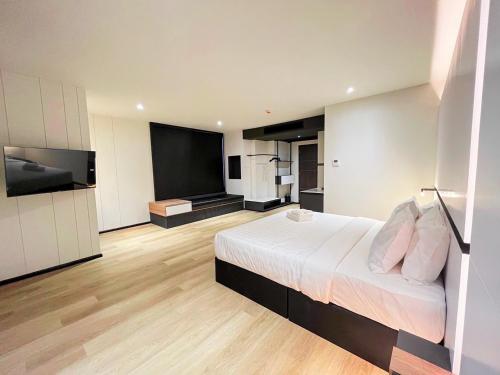 a bedroom with a bed and a flat screen tv at 9D City & 9D Express Hotel in Udon Thani
