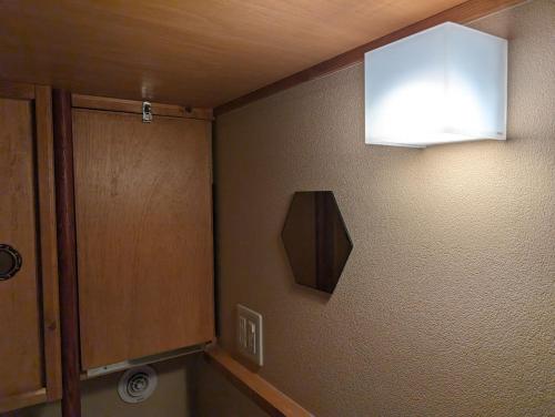 a bathroom with a sink and a light on the wall at Guest House Tokyo Samurai in Tokyo